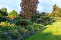 Miserden Park, Gloucestershire. The large double borders overflowing with summer planting.