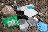 Twin scaling Galanthus 'Snowdrop' propagation step by step 1 - Picture of the necessary equipment - metylated spirit, glass chopping pane, vermiculite, polythene bags, fungicide, scalpel, lighter, labels, pencil, containers, nitrile gloves and kitchen towel.