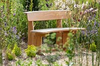 A curved wooden seat bench in The Drought Tolerant Garden at the RHS Hampton Court Palace Garden Festival 2019.