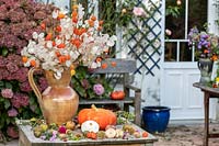 Chines lanterns and honesty in jug on a table : Lunaria and Physalis alkekengi