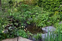 The Art of Viking Garden. A small naturalistic pool, edged in rocks and moisture-loving plants. Sponsor: Viking Cruises. RHS Chelsea Flower Show 2019.