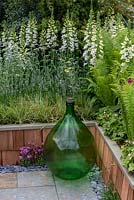Raised beds edged in timber planks, faced in cedar shingle tiles, beds planted with white Foxgloves and Ferns. 