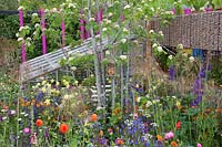 The Montessori Centenary Children's Garden, view of the colourful planting in the garden including blue Anchusa, orange Geums and Yellow Aquilegia - Sponsors: Montessori Centre International, City Asset Management.