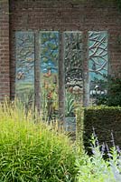Ceramic decorative panels representing four seasons on a brick wall 