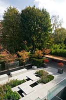Overview of modern city garden, with pale paving and planting block planting