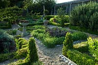 Herb parterre in the centre of formal walled vegetable and fruit garden, beds separated by gravel paths