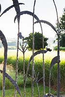 Decorative wrought iron gate picturing grasses and butterflies 