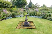 The Sundial Garden with its wooden pergola and sundial, Wollerton Old Hall Garden, Shropshire, UK. Planting includes: Japanese anemones, Dahlias, Phlox paniculata, Stachys byzantina and Salvia microphylla