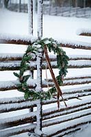 Winter decorations - simple wreath hanging on fence 