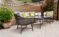 London contemporary garden patio with modern garden sofa, chairs  and table on patio with cedar batten trellis fencing behind.