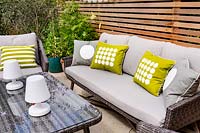 London contemporary garden with modern garden sofa, chairs and table on patio with cedar batten trellis fencing behind.