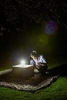 Sam Bosanquet checking his moth trap at night.