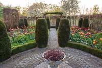 Formal spring garden with central urn and beds of spring bulbs