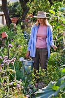 Woman holding a watering can in the vegetable garden