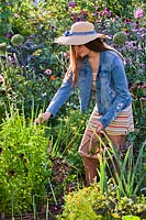 Girl picking herbs in kitchen garden