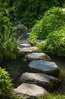 Stepping stones across small stream in Japanese-style garden