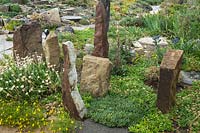 Standing sandstone pieces in a rock garden with low-growing plants