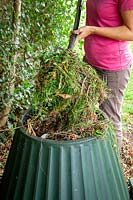 Adding suitable material to a compost bin 