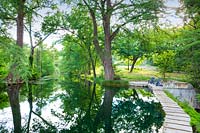 Reflections in the lake at Mill Creek Ranch in Vanderpool, Texas designed by Ten Eyck Landscape Inc, July.