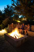 Family seated around the fire pit at Mill Creek Ranch Vanderpool, Texas designed by Ten Eyck Landscape Inc, July.