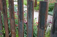 Corten steel fence in the 'Elements of Sheffield' garden at the RHS Chatsworth Flower Show 2019.
