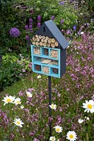 Insect hotel set amongst wildflowers in the 'RHS Garden for Wildlife Wild Woven' - RHS Chatsworth Flower Show 2019.