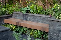 Slat seating amongst slate walls and raised beds in 'The Square Garden' at BBC Gardner's World Live 2018.