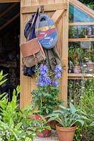 Gardener's equipment hanging from greenhouse door. RHS Hampton Court Palace Garden Festival, 2019.