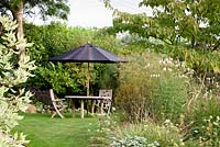 Sun shade and table on the front lawn at the Old Vicarage, Weare, Somerset, UK