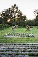Formal garden with panels of sedums and succulents set between sunken railway sleepers and terracotta pots of Hydrangeas 