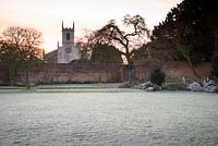 The croquet lawn on a frosty March morning at Doddington Hall, Lincolnshire with St Peter's Church