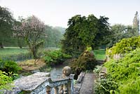 View from the boat terrace to water meadows beyond the river at Heale Gardens, Wiltshire, UK. 
