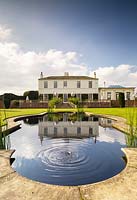 View to Littlethorpe Manor across the Fountain Pool and lawn. Yorkshire, UK. Designed by Eddie Harland.