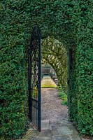 View through metal gateway to garden beyond. Fittleworth House, West Sussex, UK. 
