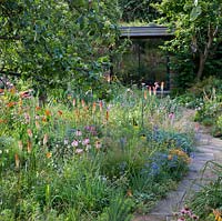 View of mixed border and pathway leading to a garden room in Dr. James Hitchmough's garden, Sheffield. 