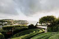 Jardin Impressions with wicker statue of Claude Monet overlooking the sea. Les Jardins d Etretat, Normandy, France