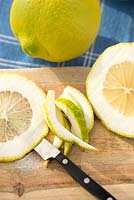 Citrus medica being sliced on a board.