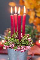Arrangement with Hebe, Rowan berries and red candles. 