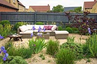 Gravel garden with rattan outdoor furniture and a fire bowl