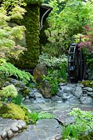 Japanese garden with stream and water wheel, depicting paradise and tranquility - RHS Chelsea Flower Show 2014