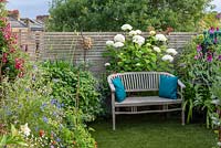 Seating area on roof terrace with mixed planting.

