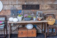 A table in the covered dining area decorated with pots of succulents and various salvaged objects.
