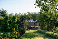 Path leading to Wooden Yurt through a vegetable garden behind