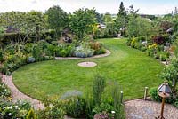 An aerial view of a two-thirds-of-an-acre country garden with large S-shaped lawn 