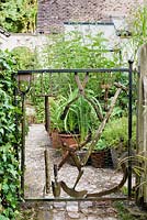 Decorative gate made using old rusty tools including trowels, hedge shears, hoe and scythe 