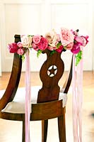 Roses 'moody blues','pink piano' and 'o'hara' made into a rose garland on a chair back used for Wedding decoration 
