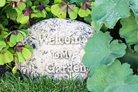 Stone with carved inscription: Welcome to my Garden.