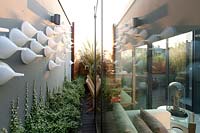Wall of terrace decorated with plastic funnels reflected in veranda glass 