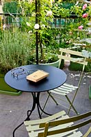 Bistro dining set on a terrace with rose 'brise parfum'