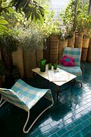 Table and chairs on blue tiled terrace 